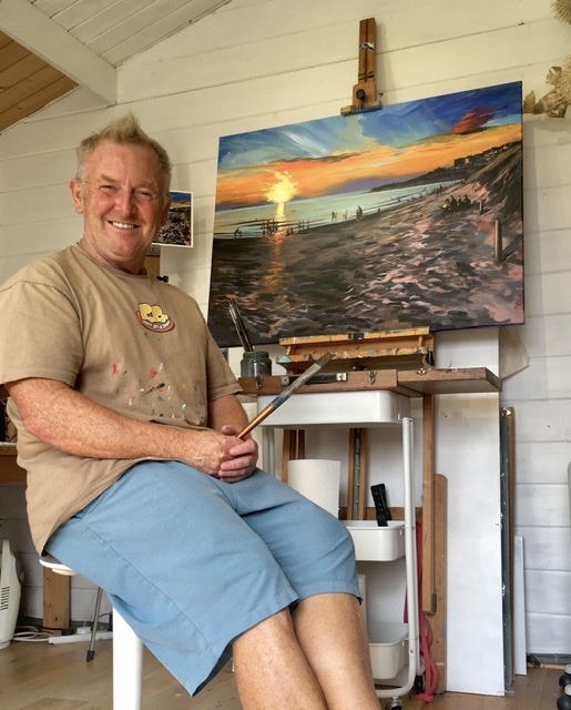 Devon artist Steve PP sitting at the easel in his Woolacombe painting studio