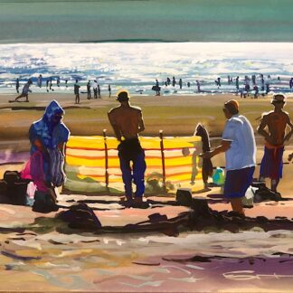 People on a beach with a yellow windbreak at sunset