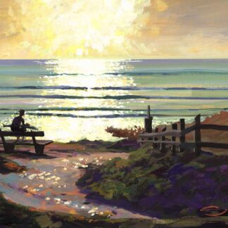Gazing Out across the sun sparkled sea a surfer sits on a bench near the beach