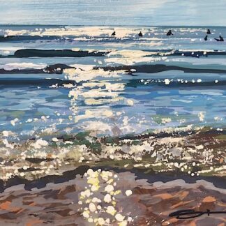surfers sat in the sea waiting for waves in the sunshine