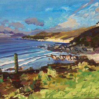 Winter Light shining on Morte Point North Devon as waves roll into Combesgate Beach under a blue sky with light clouds
