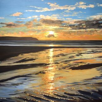 Colourful winter sunset painting reflecting in the wet sand on Woolacombe beach