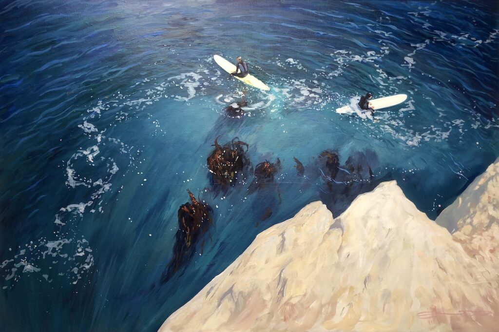 two surfers sitting on their surfboards in the ocean