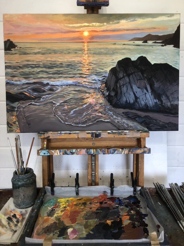 Combesgate Sunset Woolacombe painting by artist Steve PP on an easel in his Woolacombe art studio
